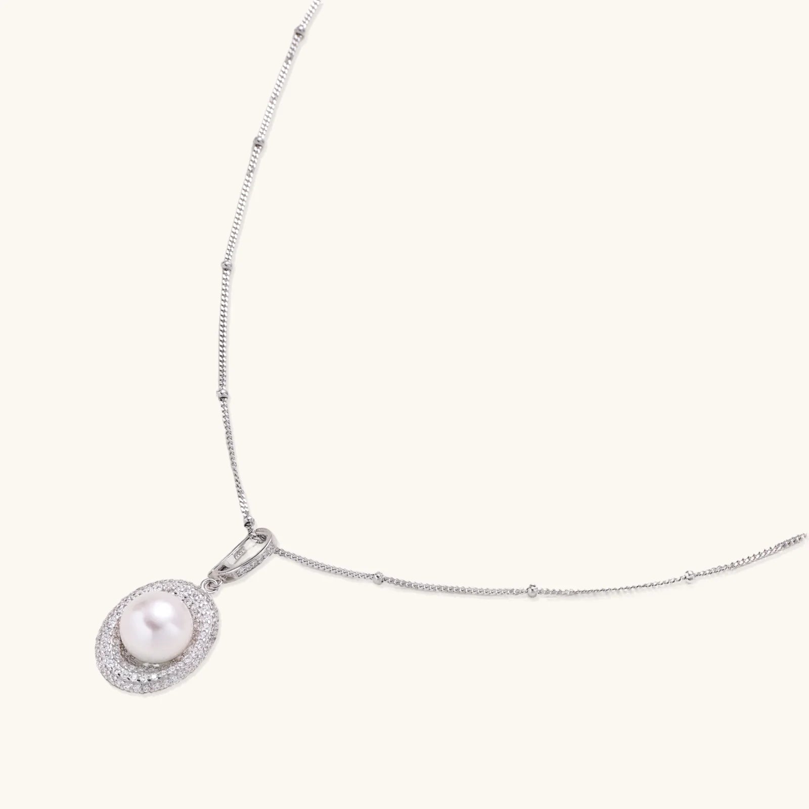 Oval sterling silver pendant with crystal halo surrounding a white freshwater pearl on delicate chain